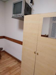 a room with a cabinet and a tv on a wall at Скай Румс -3 in Sofia