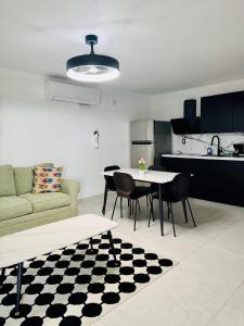 a living room with a couch and a table and chairs at Brand New Luxe 2BR Apt Near SJU & Airport in Carolina