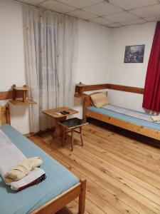 a room with two beds and a table at Скай Румс -3 in Sofia