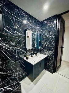 a black marble bathroom with a sink and a mirror at Brand New Luxe 2BR Apt Near SJU & Airport in Carolina +26 photos