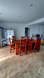 a dining room with a wooden table and chairs at MJA's Retreat in Arorangi
