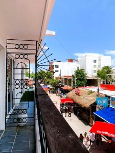 a balcony of a building with people walking on a street at Casa calendario azteca in Playa del Carmen