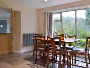 a dining room with a table and chairs and a window at The Mill Cottage in Ault Hucknall +17 photos