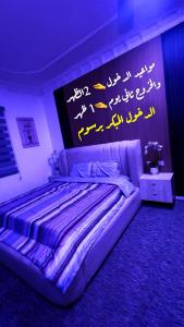 a bedroom with a bed with writing on the wall at استوديو 104 in Tabuk