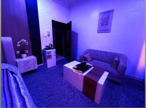 a living room with a purple couch and a table at استوديو 104 in Tabuk