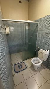 a bathroom with a toilet and a glass shower at Casas de Praia do Coqueiro com AR e varandas in Luis Correia
