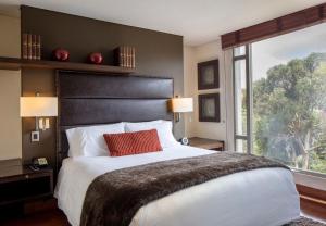 a bedroom with a large bed with a large window at Hotel Cabrera Imperial By key 33 in Bogotá +57 photos