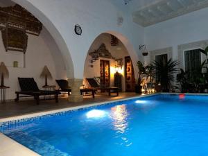 a large swimming pool in a house with an archway at Guesthouse DarHamdoun in Ḩammām al Ghazzāz