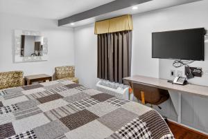 a hotel room with a bed and a desk at 12 Oaks Hotel in Tyler +30 photos