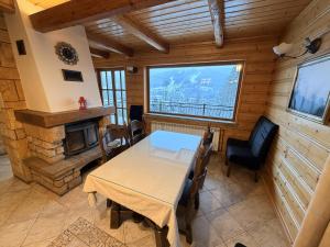 a dining room with a table and a fireplace at Summit View Wisła in Wisła