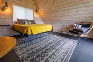 ein Schlafzimmer mit einem Bett, einem Stuhl und einem Teppich in der Unterkunft Tiny Town Campground in Emigrant