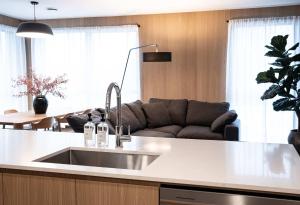 a kitchen with a sink and a couch in a room at Luna Ridge - Thoughtfully Designed 3-Bedroom Condo in Revelstoke