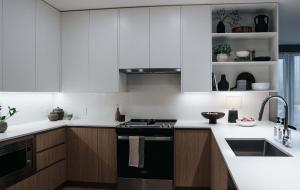 a kitchen with white cabinets and a black stove top oven at Luna Ridge - Thoughtfully Designed 3-Bedroom Condo in Revelstoke
