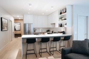 a kitchen with a counter and stools in a kitchen at Luna Ridge - Thoughtfully Designed 3-Bedroom Condo in Revelstoke