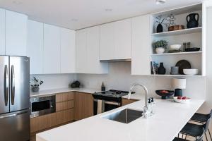a kitchen with white cabinets and a stainless steel refrigerator at Luna Ridge - Thoughtfully Designed 3-Bedroom Condo in Revelstoke