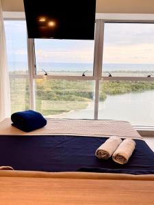a bed in a room with a large window at Bugan Premium 16 andar - vista mar incrível in Recife +24 photos