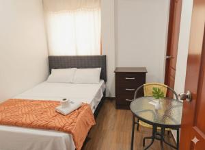 a small room with two beds and a glass table at Hospedaje Dajoka's in Lima