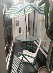 a table and chairs on a balcony with a cactus at Hospedaje Dajoka's in Lima