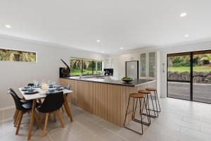 a kitchen and dining room with a table and chairs at Clay Cottage in Waimauku