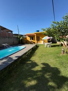 a backyard with a swimming pool and a house at CasadaKassia in Itapemirim