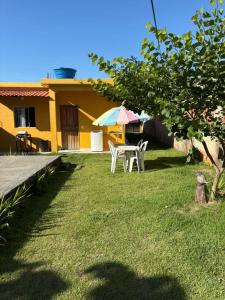 a table with an umbrella in the yard of a house at CasadaKassia in Itapemirim