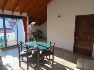 a table with chairs and a vase of flowers on it at SANTA HELENA HOSPEDERIA in Tibasosa
