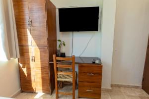 a room with a desk with a television and a chair at Nuiya Hoteles Centro in Sayulita