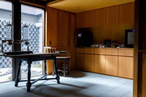 a kitchen with a table and a counter in a room at 黒梅屋 Kurumiya in Kanazawa