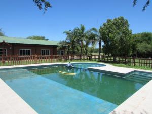 a swimming pool in a yard with a wooden fence at Chalet 1 Dormitorio Kallpa in Santiago del Estero