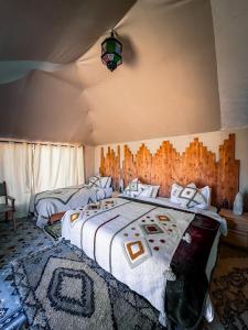 a bedroom with a large bed with a comforter at Authentic Luxury Camp in Merzouga