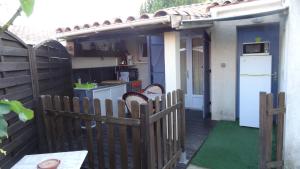 a backyard with a wooden fence and a kitchen at Suite Harlequin in Cournonterral