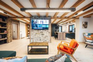 a living room with a tv on a brick wall at Fox Chalet in Molidu