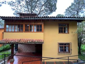 a yellow house with windows and a balcony at Casa del Bosque in Mazamitla +18 photos