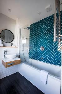 uma casa de banho com uma banheira, um lavatório e um chuveiro em Victoria Inn em Londres