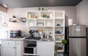 a kitchen with white cabinets and a refrigerator at BOHO-MOD STUDIO APARTMENTs in Ferris