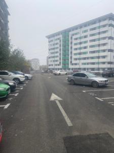 a parking lot with cars parked in front of a building at Apartament Premium Militari Parcare Self Check-in in Roşu