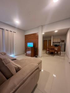 a living room with a couch and a flat screen tv at Residencia Pura Vida in Capiatá