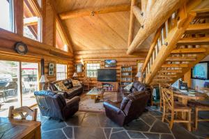a living room with leather furniture and a wooden ceiling at Nature's Inn Bed and Breakfast in Ahwahnee