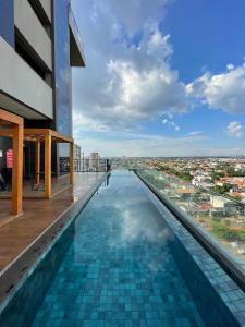 a swimming pool on the roof of a building at Lindo Studio Com Vista para Cidade in Campo Grande