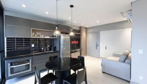 a kitchen with a table and chairs in a room at Lindo Studio Com Vista para Cidade in Campo Grande