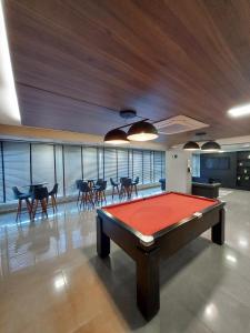 a pool table in a room with tables and chairs at Lindo Studio Com Vista para Cidade in Campo Grande