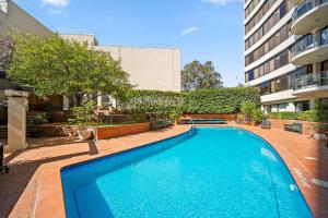 a large blue swimming pool in front of a building at Lakefront Panorama – Classic in Canberra