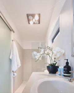 a white bathroom with a sink and a window at Salt Box Hideaway in Strahan +81 photos