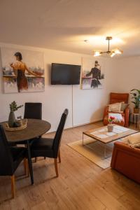 a living room with a table and a tv on a wall at Haus Eifelglück am Stausee Obermaubach in Kreuzau