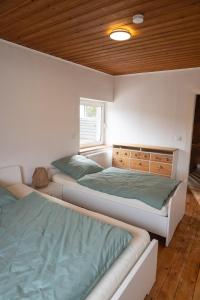 a bedroom with two beds and a window at Haus Eifelglück am Stausee Obermaubach in Kreuzau +13 photos