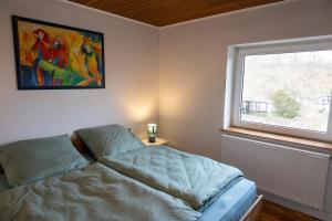 a bedroom with a bed and a window at Haus Eifelglück am Stausee Obermaubach in Kreuzau