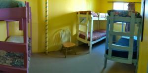 a room with three bunk beds and a chair at MobyDick Hostel in Seward +3 photos