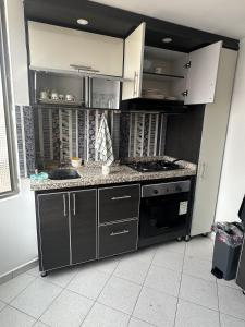 a kitchen with a stove and a counter top at Siga Sumercé Apartamento completo centro de Duitama in Duitama +4 photos