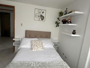 a bedroom with a bed with white sheets at Siga Sumercé Apartamento completo centro de Duitama in Duitama