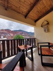 a balcony with a table and a bench and mountains at Dúplex céntrico LAS SOFIAS - PURMAMARCA in Purmamarca